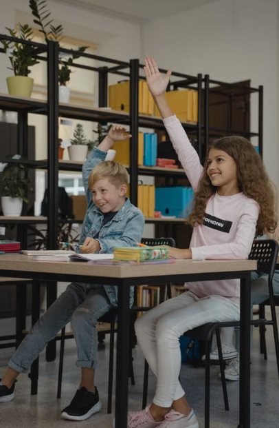 Deux élèves lèvent la main dans une salle de classe